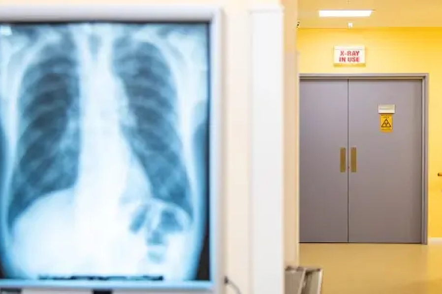Long shot of a hospital corridor with an x-ray of a skeleton.