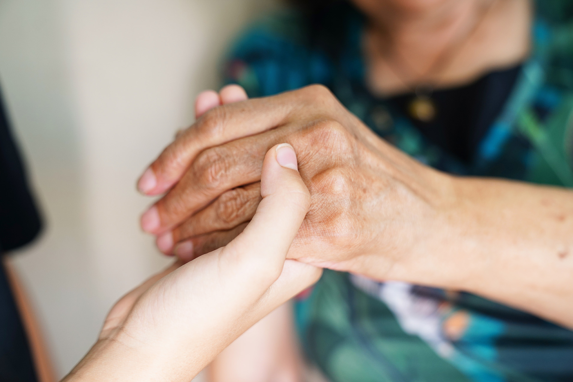 A nurse holding hands with an aged care resident.